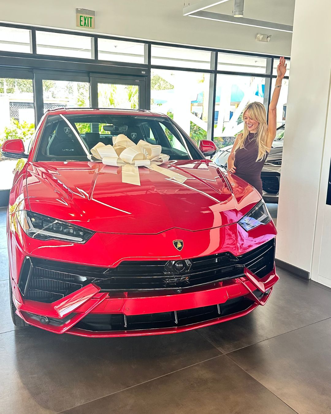 Leanne on delivery day with her red Lamborghini Urus