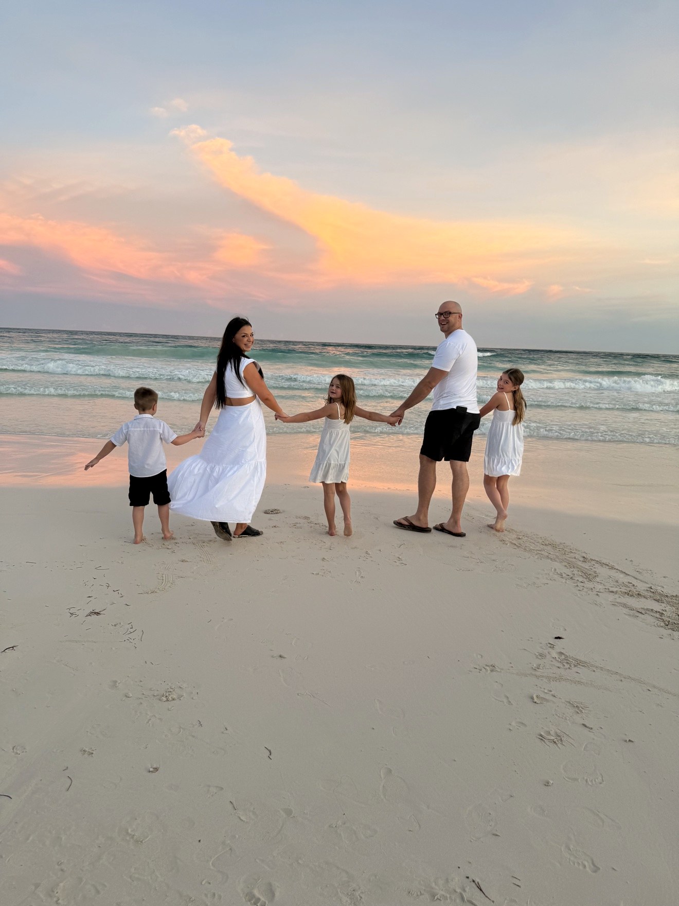Dr. Elise with her husband and three kids on the beach at sunset