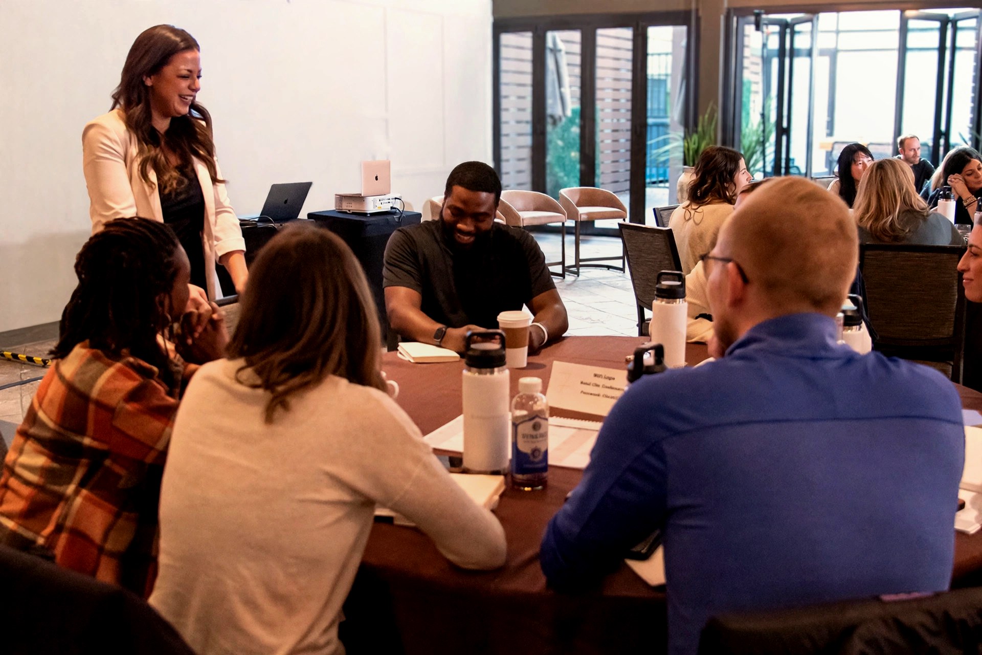 Dr. Elise coaching founders around a table at a live ChiroIntensive event