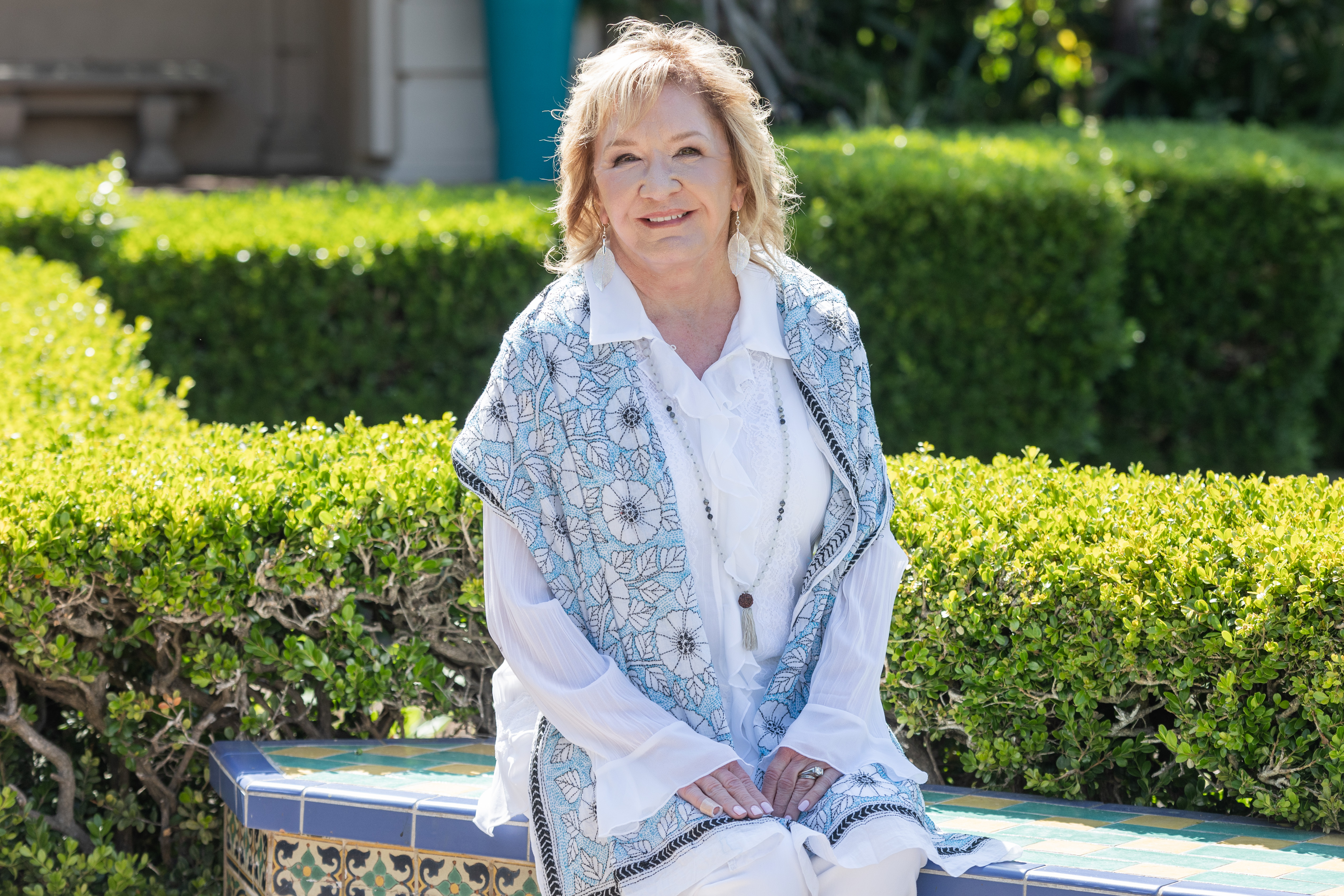Deb smiling, flower garden