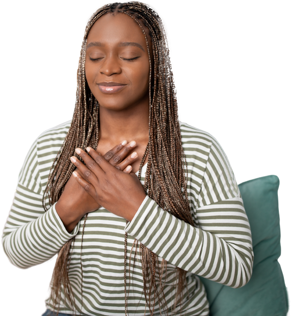 A woman seated with her hands resting over her heart, eyes closed