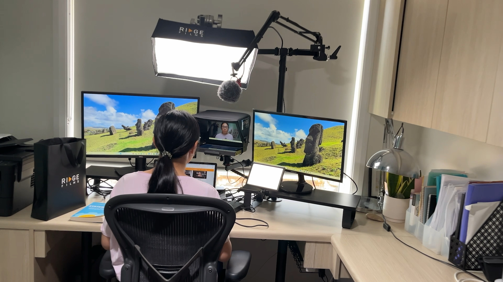 A client recording at a home office desk with dual monitors