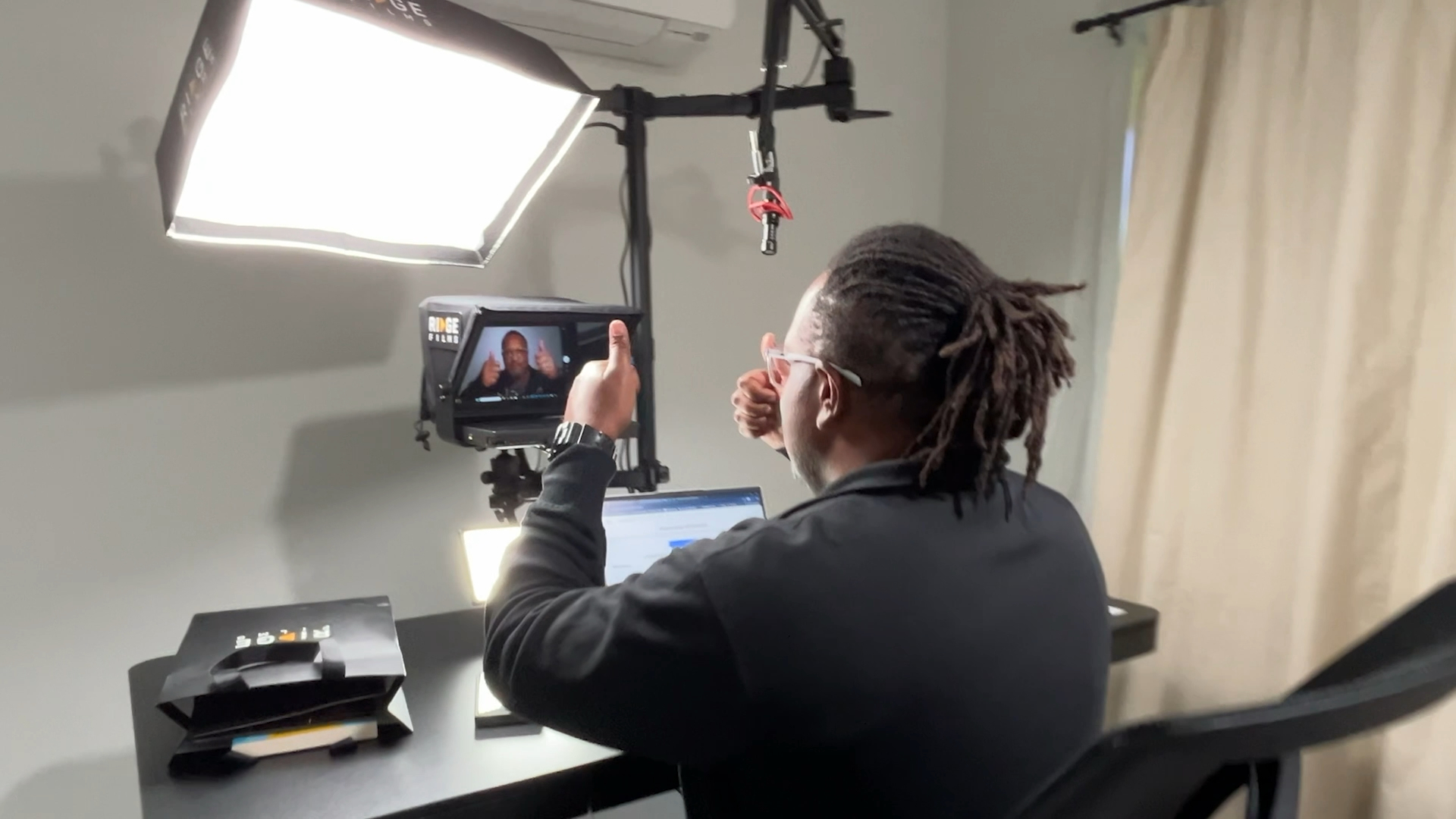 A client mid-take, gesturing to the teleprompter camera