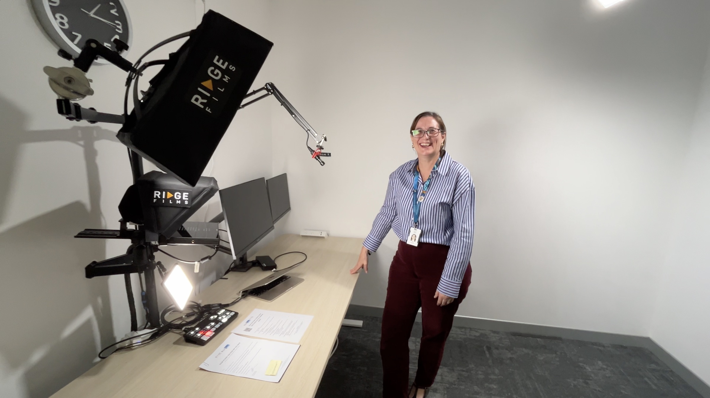 A client in her corporate office giving a thumbs up beside her studio setup