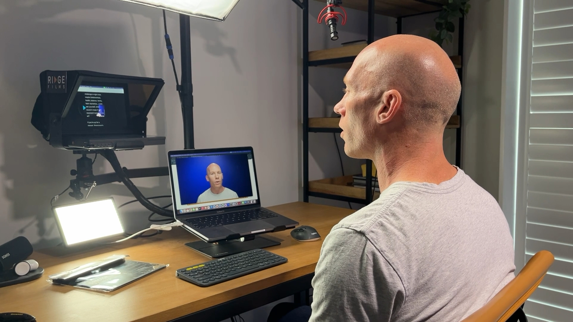 A client recording to the teleprompter at his desk