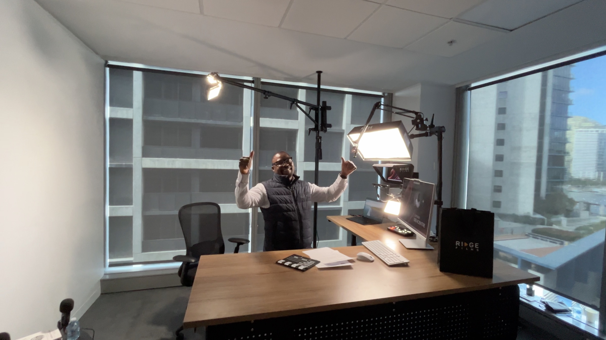 A client celebrating with both arms raised in his high-rise office studio