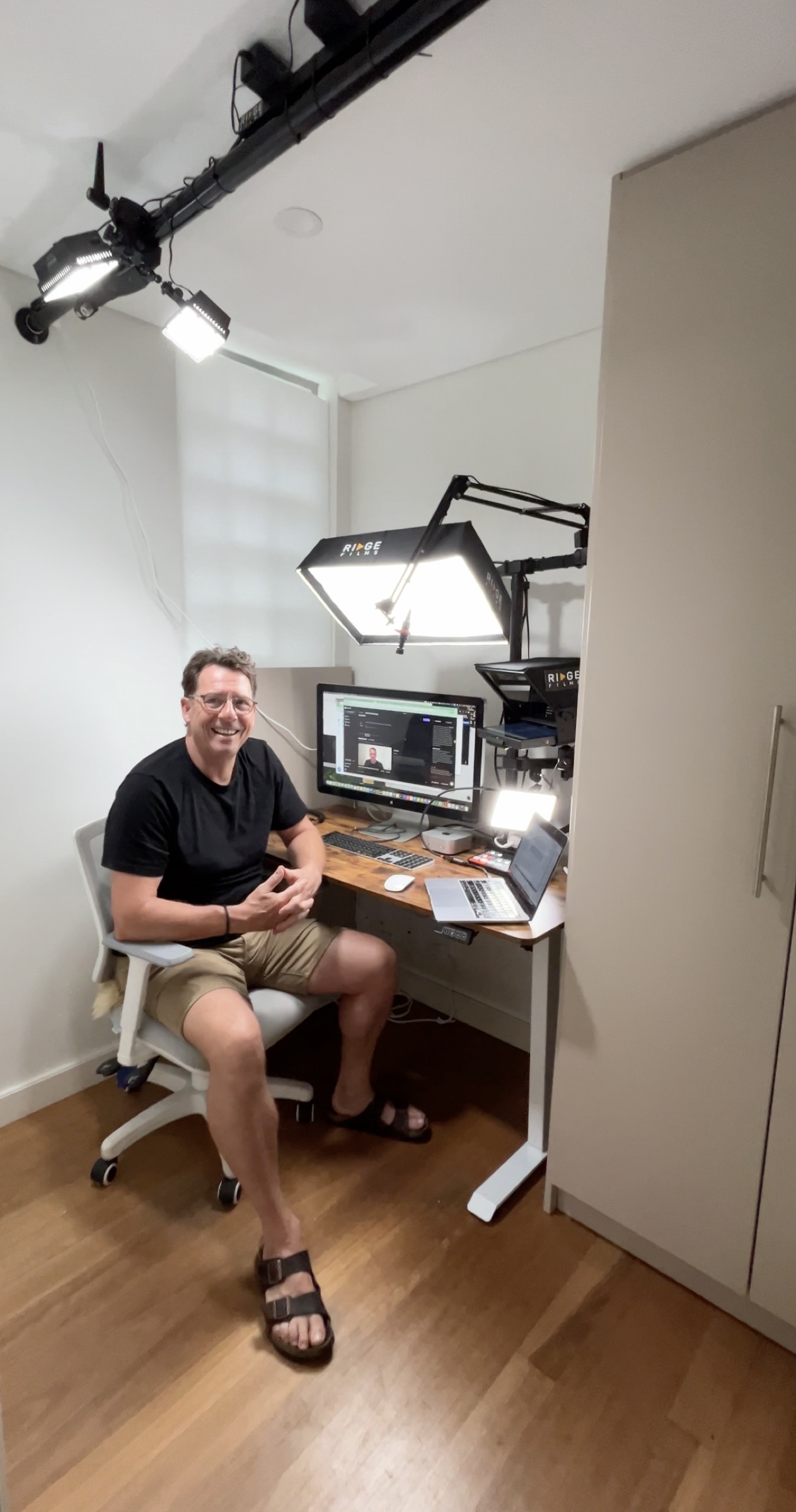 A client relaxed and smiling at his home office standing desk