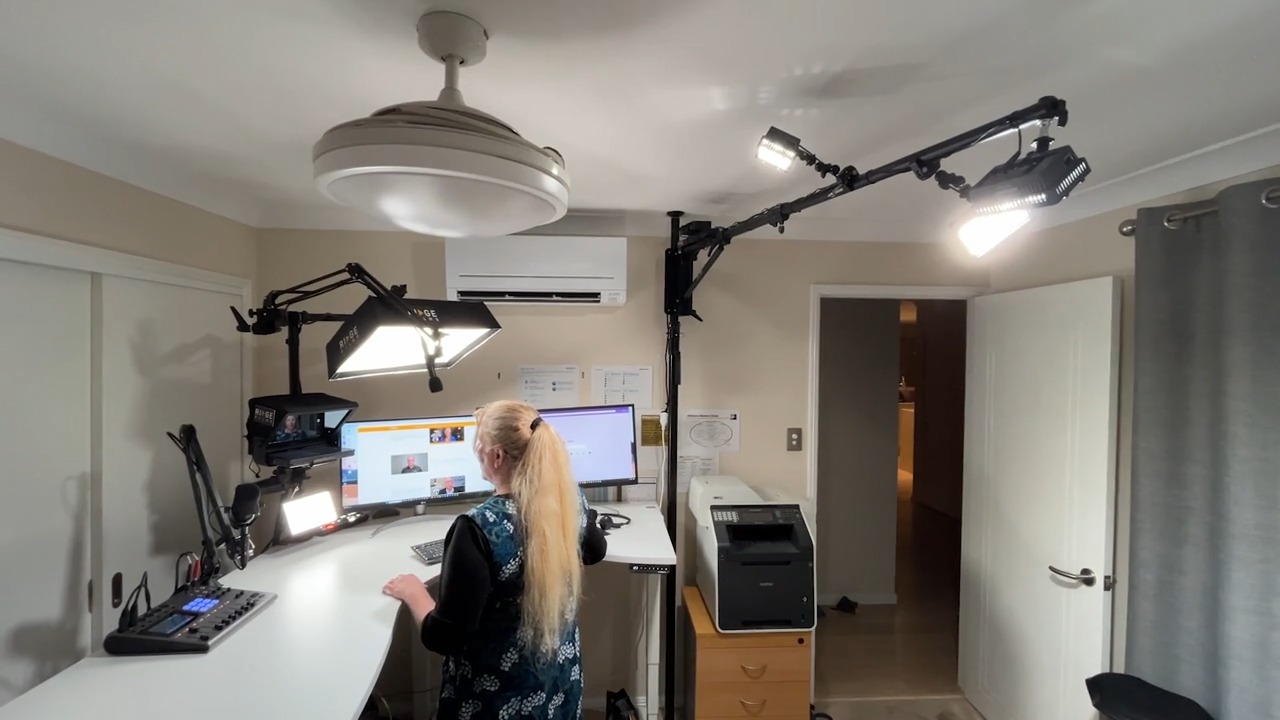 A client at a standing desk with the studio track lights overhead
