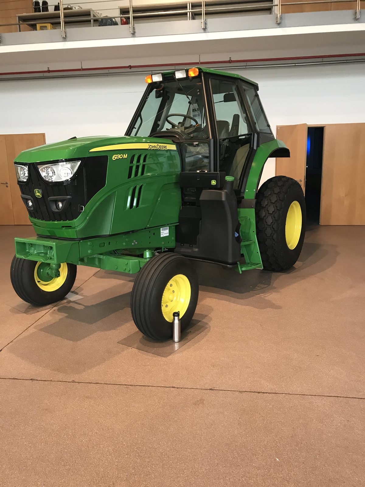 A John Deere 6130M tractor on an indoor display.