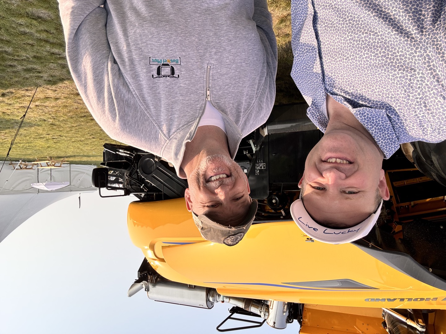 A conversation at Ag in Motion, with Bushel Plus branding and New Holland equipment in view.