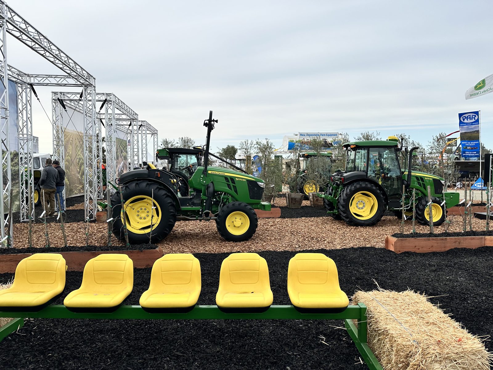 Narrow-profile John Deere 5075EN tractors on display.