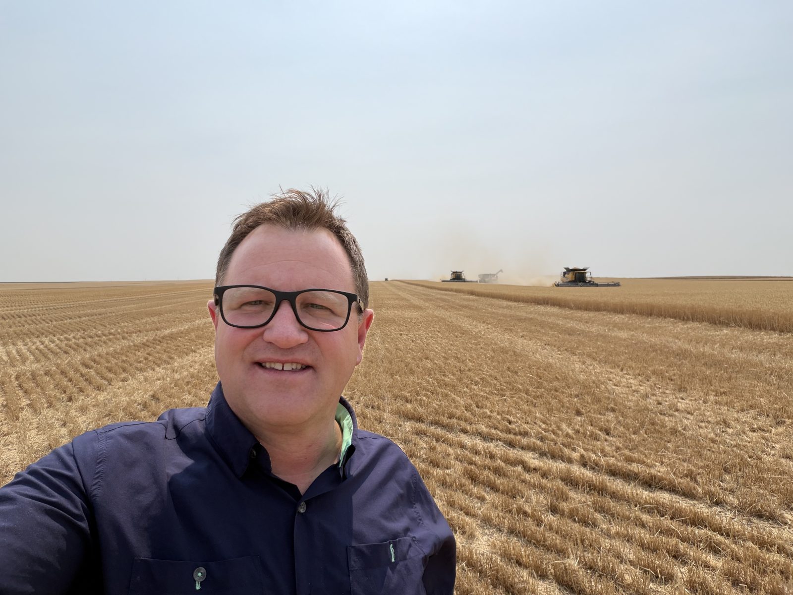Combines and crop residue mark a busy harvest field.