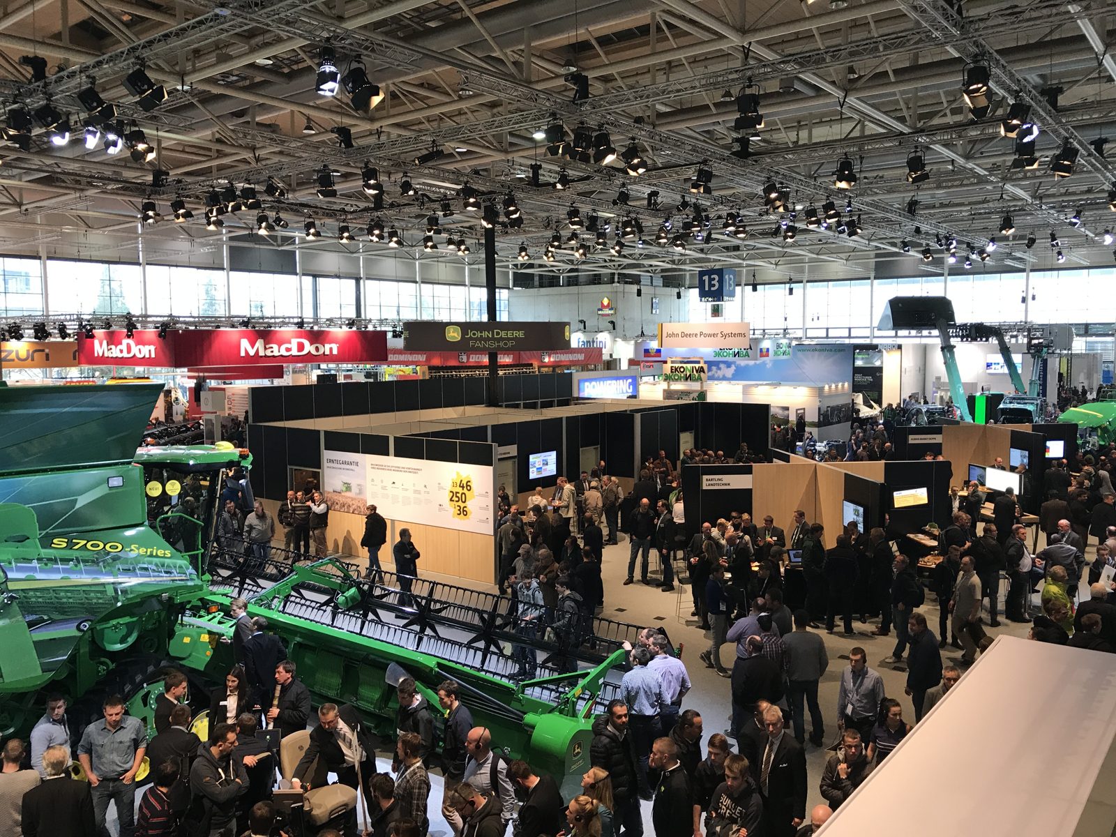 A view across the trade-show floor with John Deere harvesting equipment.