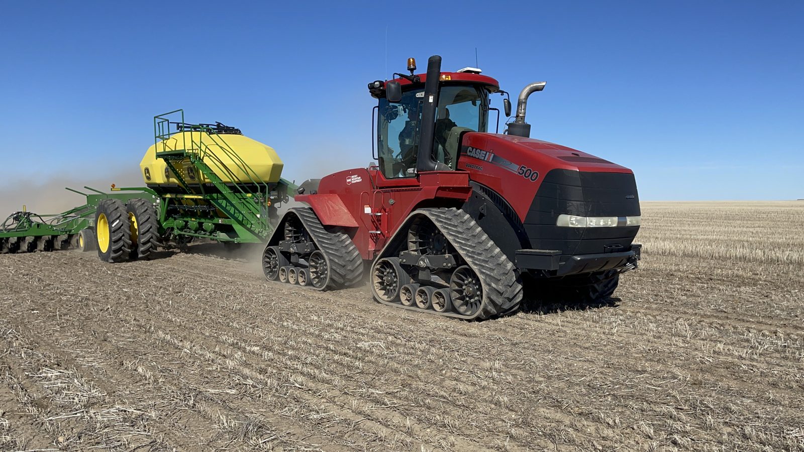 A Case IH Quadtrac 500 working with John Deere seeding equipment.