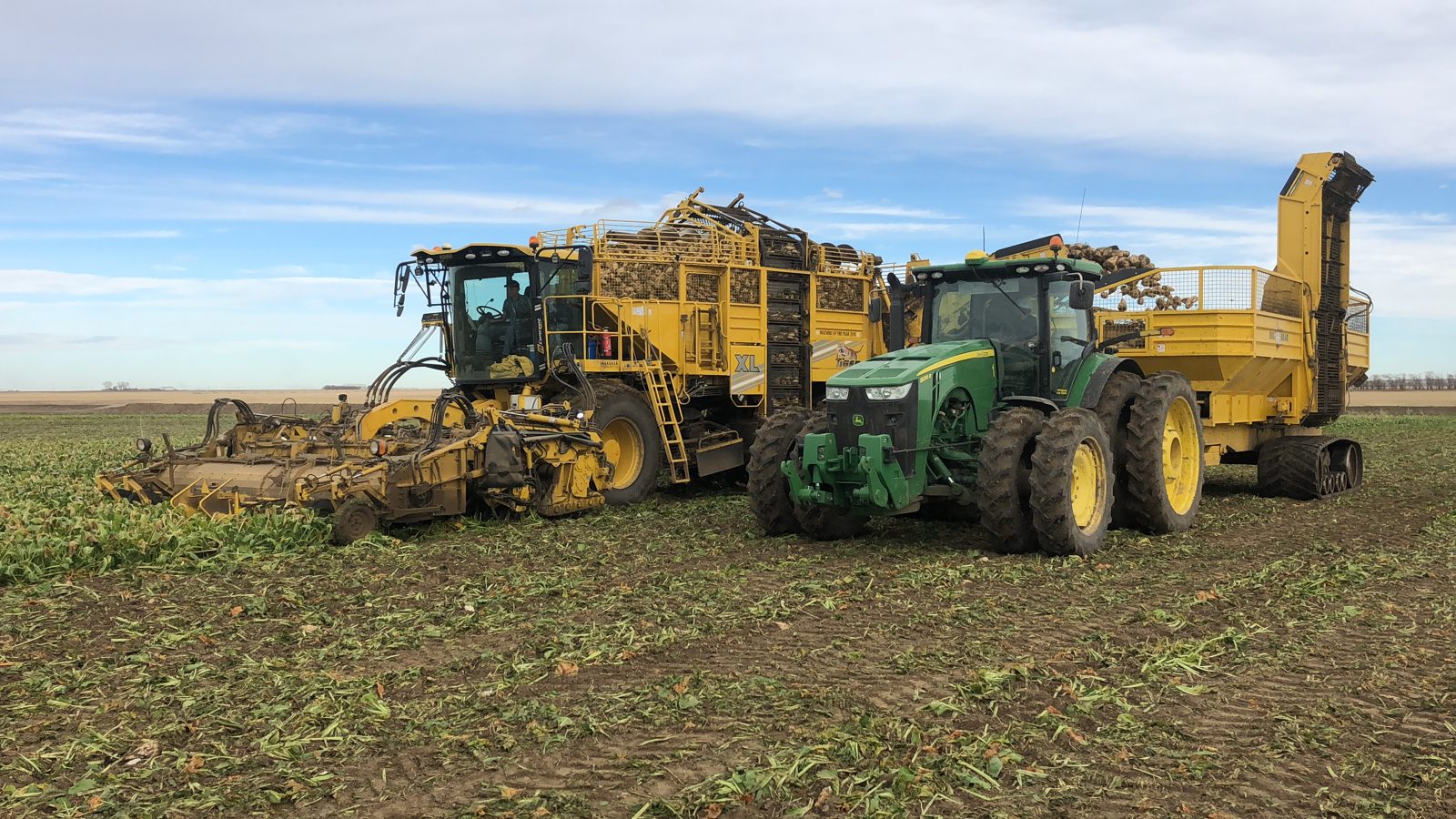 ROPA harvesting equipment working alongside a tractor and wagon.