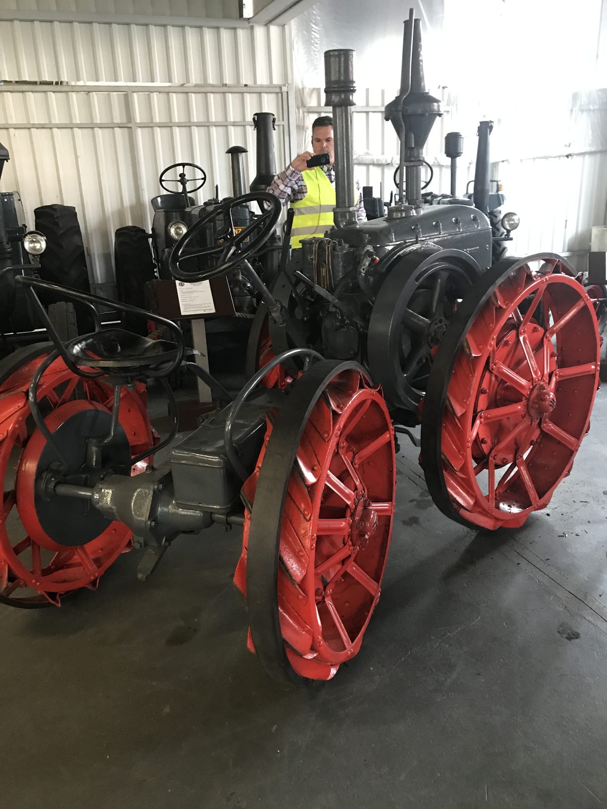Historic tractors with steel wheels and exposed mechanical components.