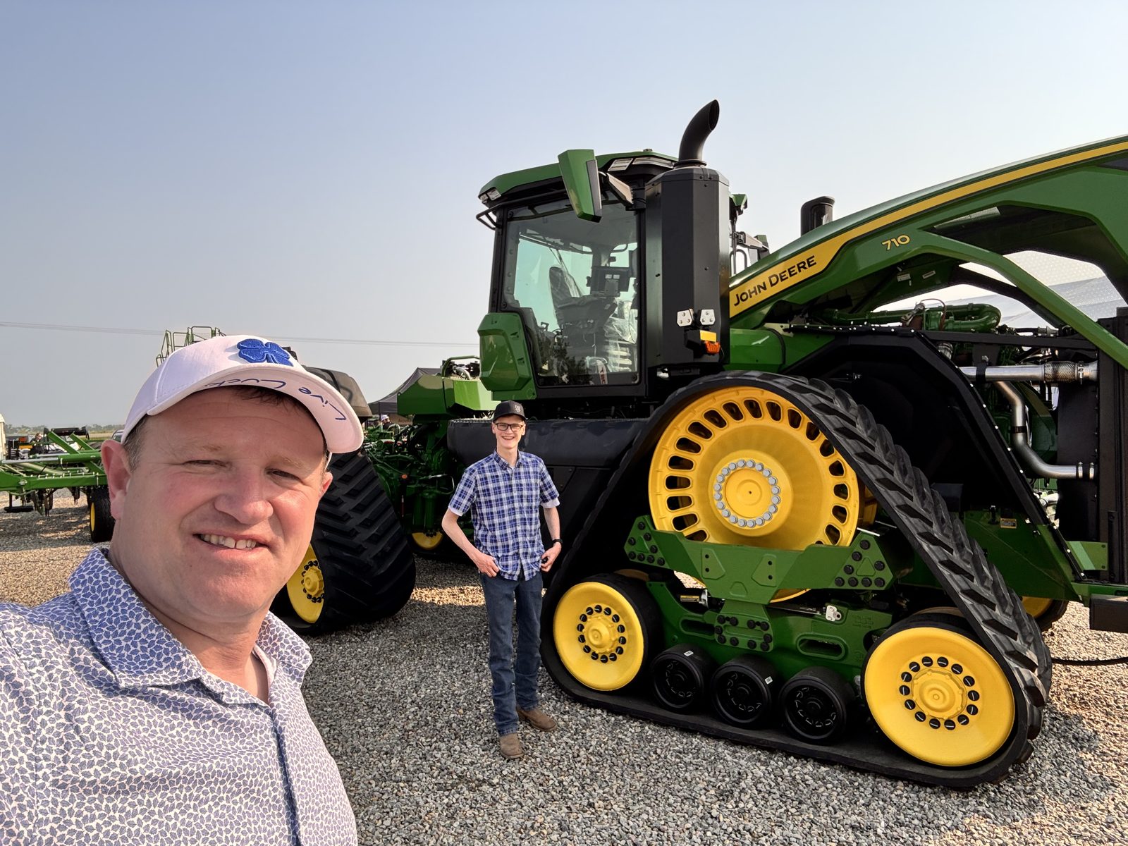 A large four-track John Deere tractor on display.