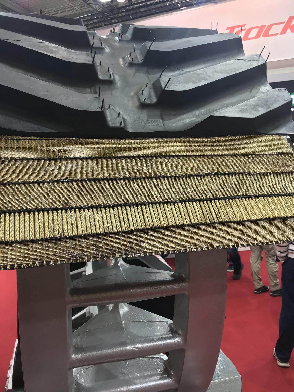 A cutaway display reveals the reinforcing layers beneath the tread.