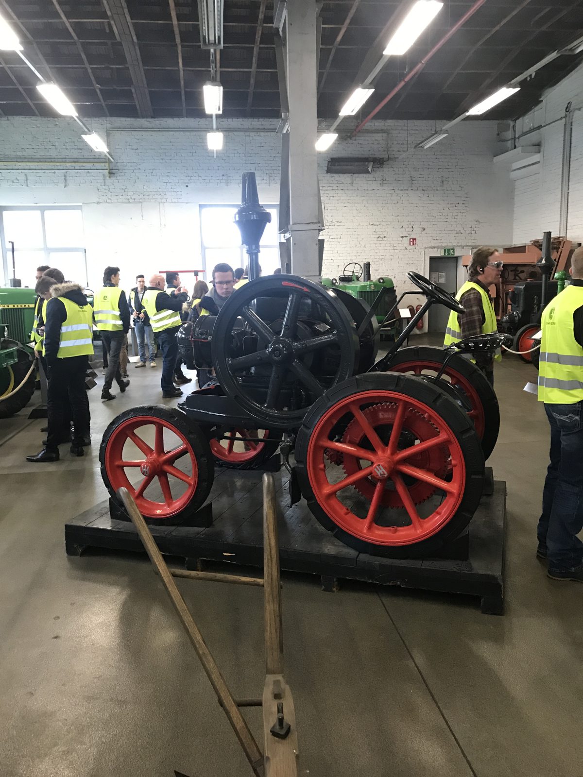 Visitors touring a collection of early tractors.