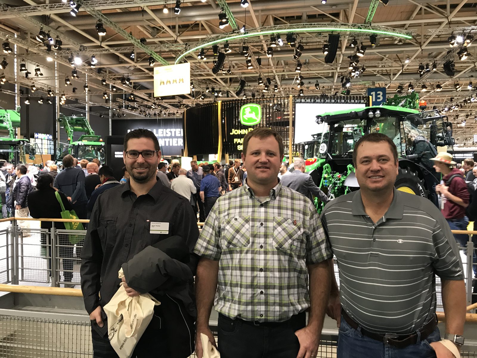A group photo among tractors and industry displays.