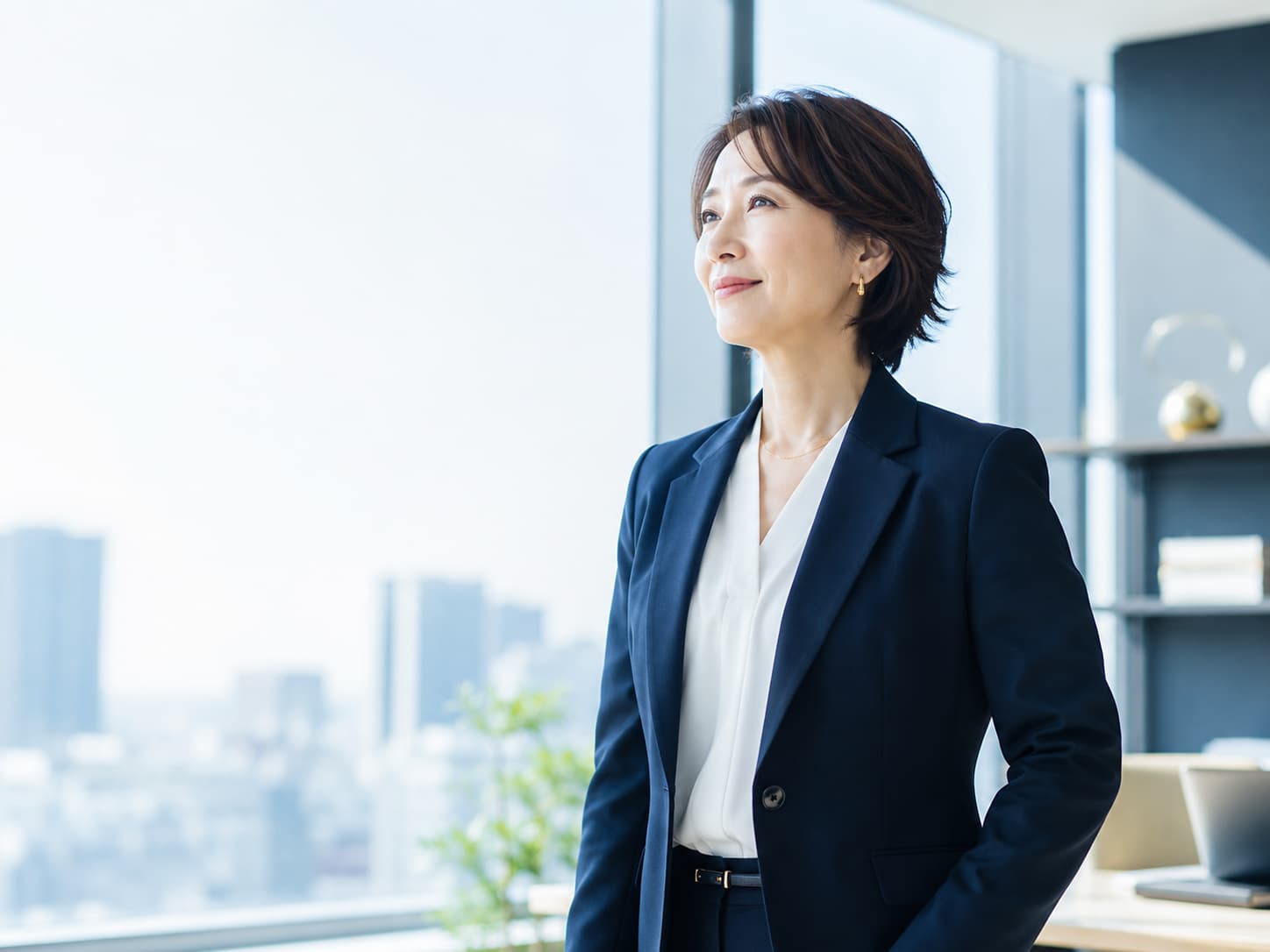 窓辺で前向きな表情を見せる女性リーダー