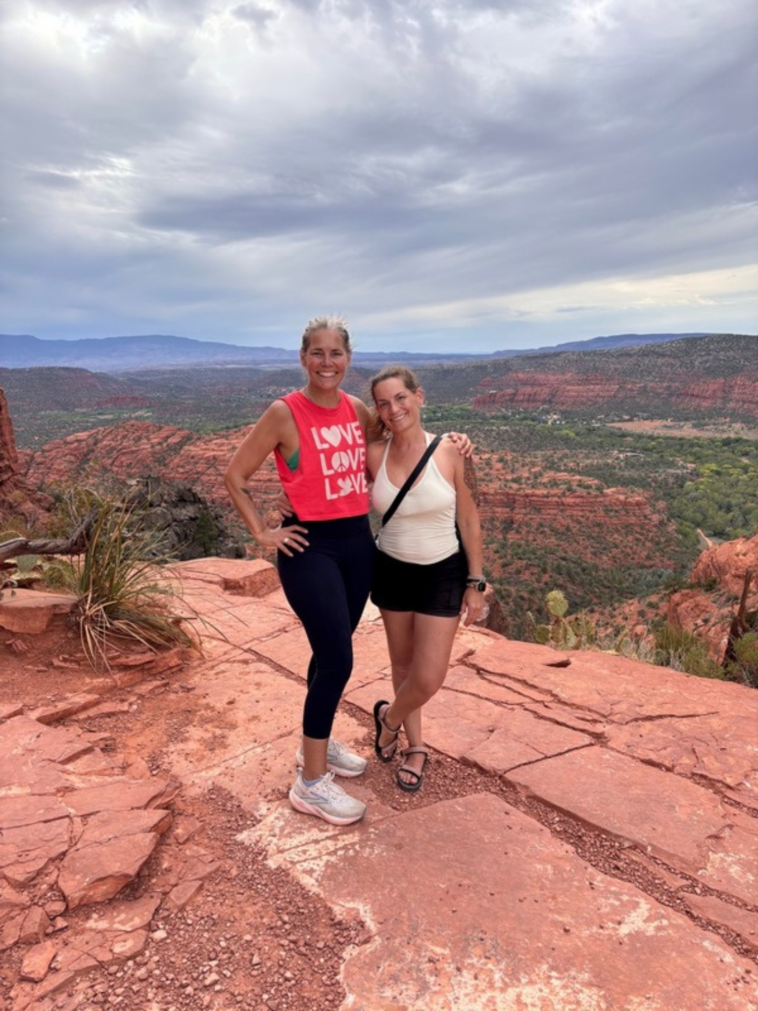 Nadia Ahrens and Melissa Ratliff-Sorrell standing on a red rock summit in Sedona