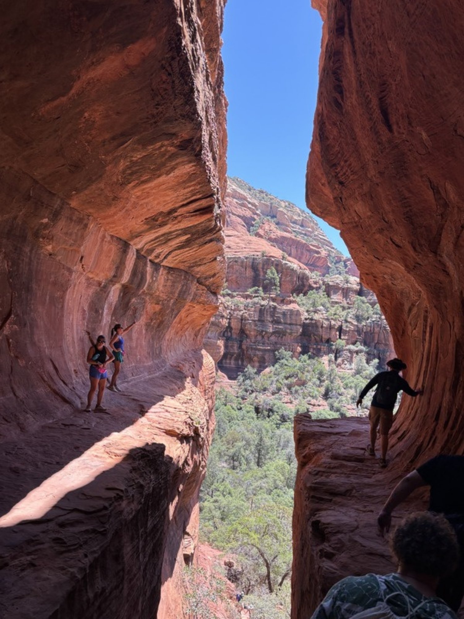 Women hiking through a red rock canyon alcove