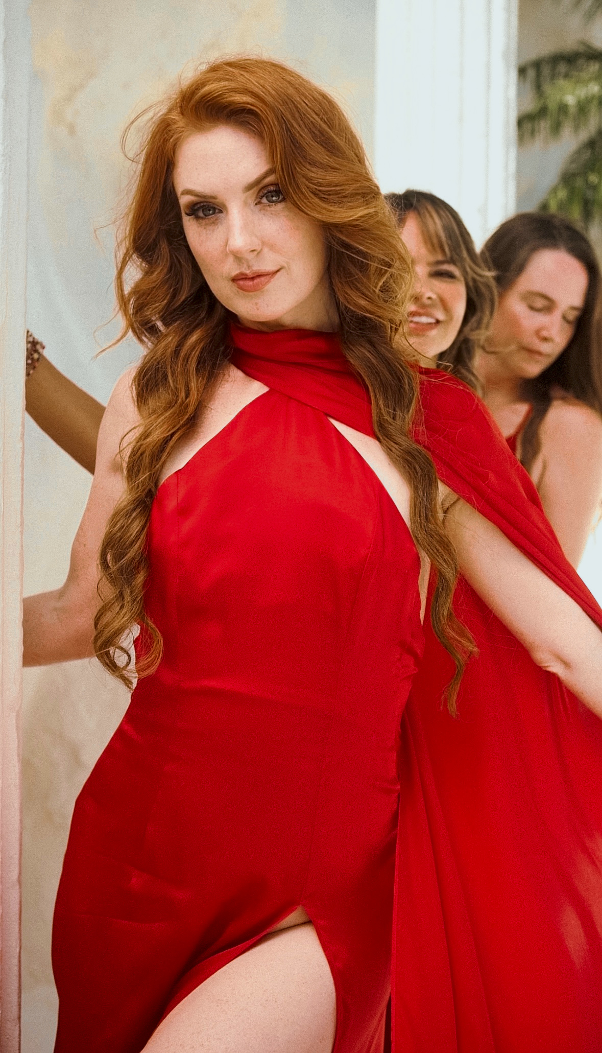 Michelle Pound in a red gown with two women behind her at the Temple