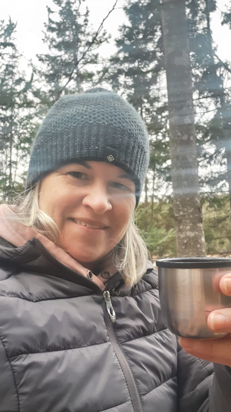 Carol enjoying hot chocolate on her favorite hiking trail
