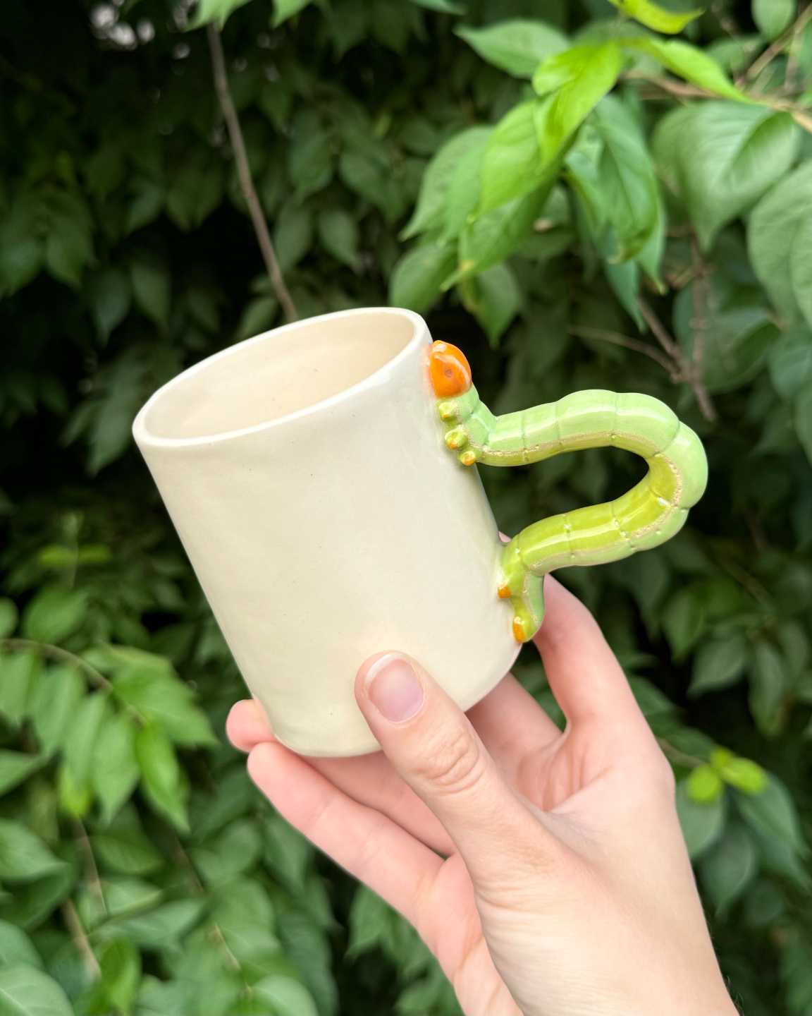 Ceramic mug with a sculpted caterpillar handle