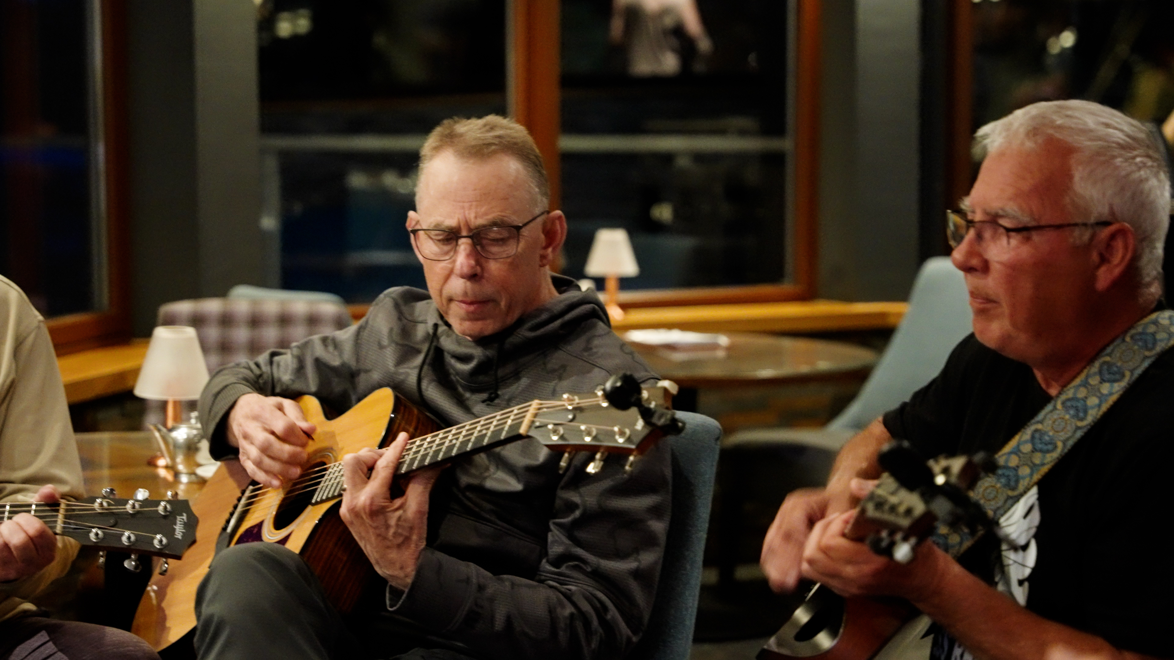Two guests playing guitars in the lounge in the evening