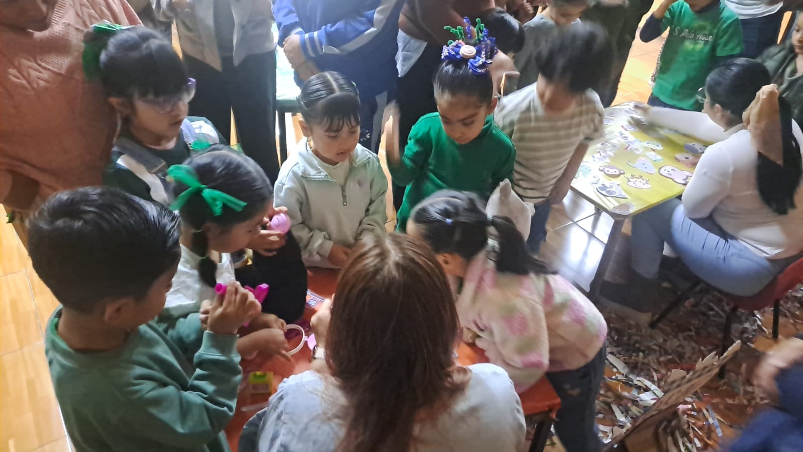 Niños de preescolar reunidos alrededor de una mesa de actividades
