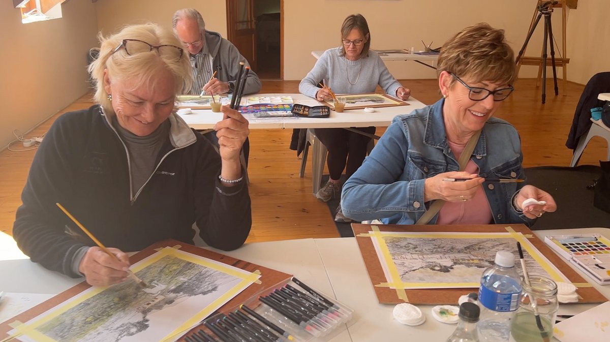 Students working on their pieces around a table in the studio