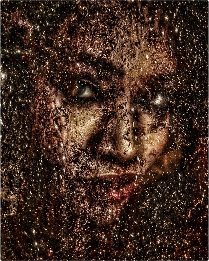 Face emerging from a speckled paint overlay