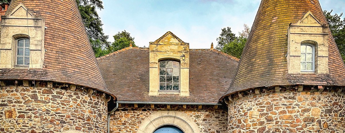 Stone château with two conical towers in rural France