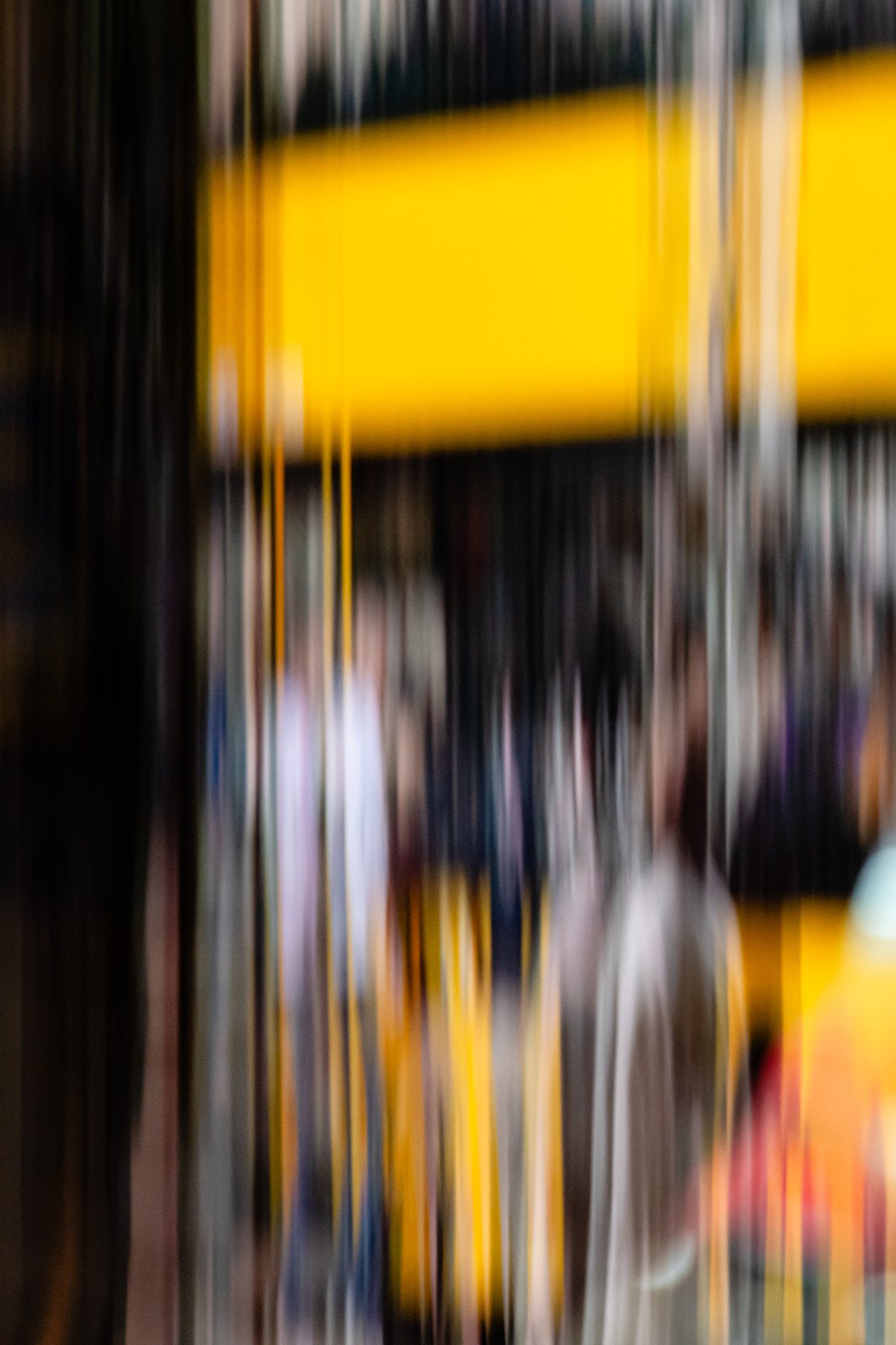 City Life 3, a crowd beneath a bright yellow awning, the street dissolved into vertical movement