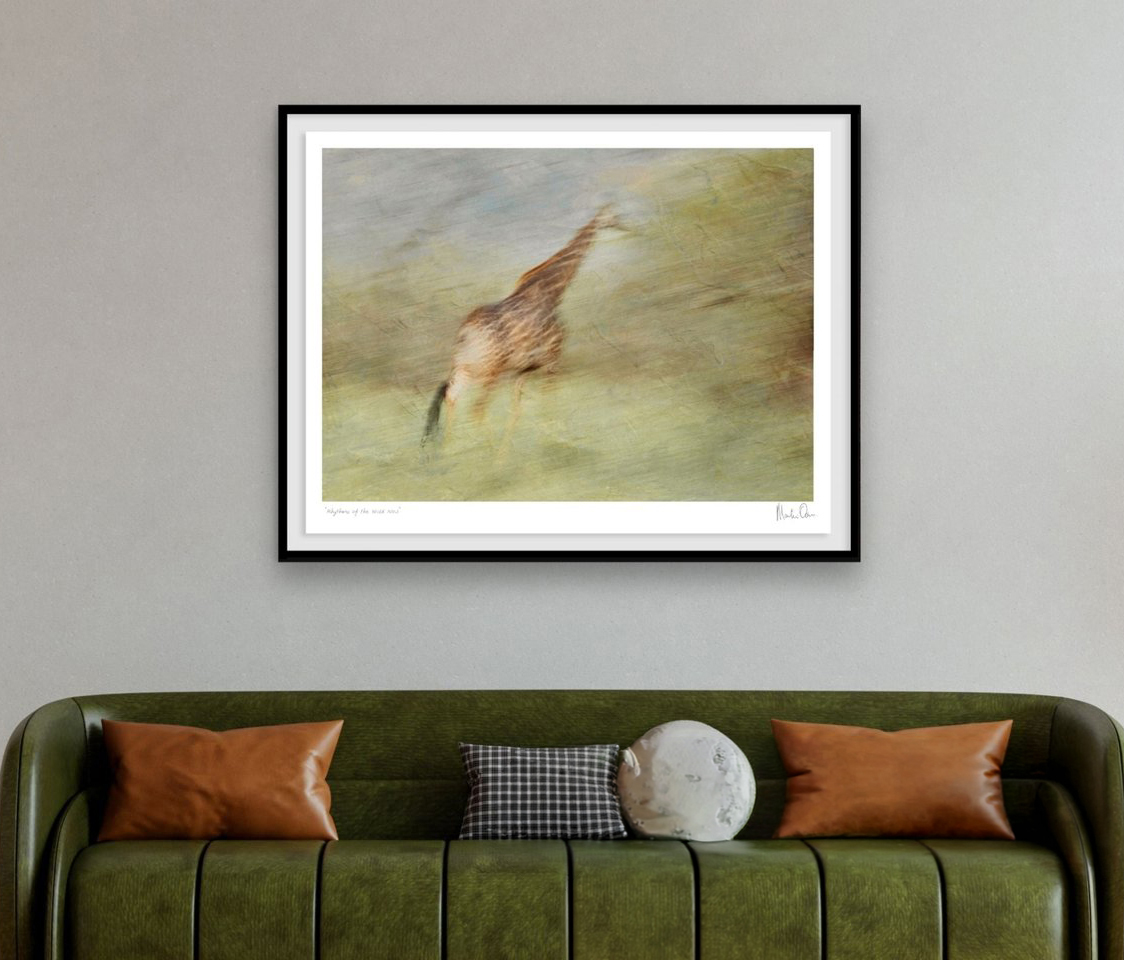 Expressions of the Wild, a framed giraffe artwork hanging above a green sofa