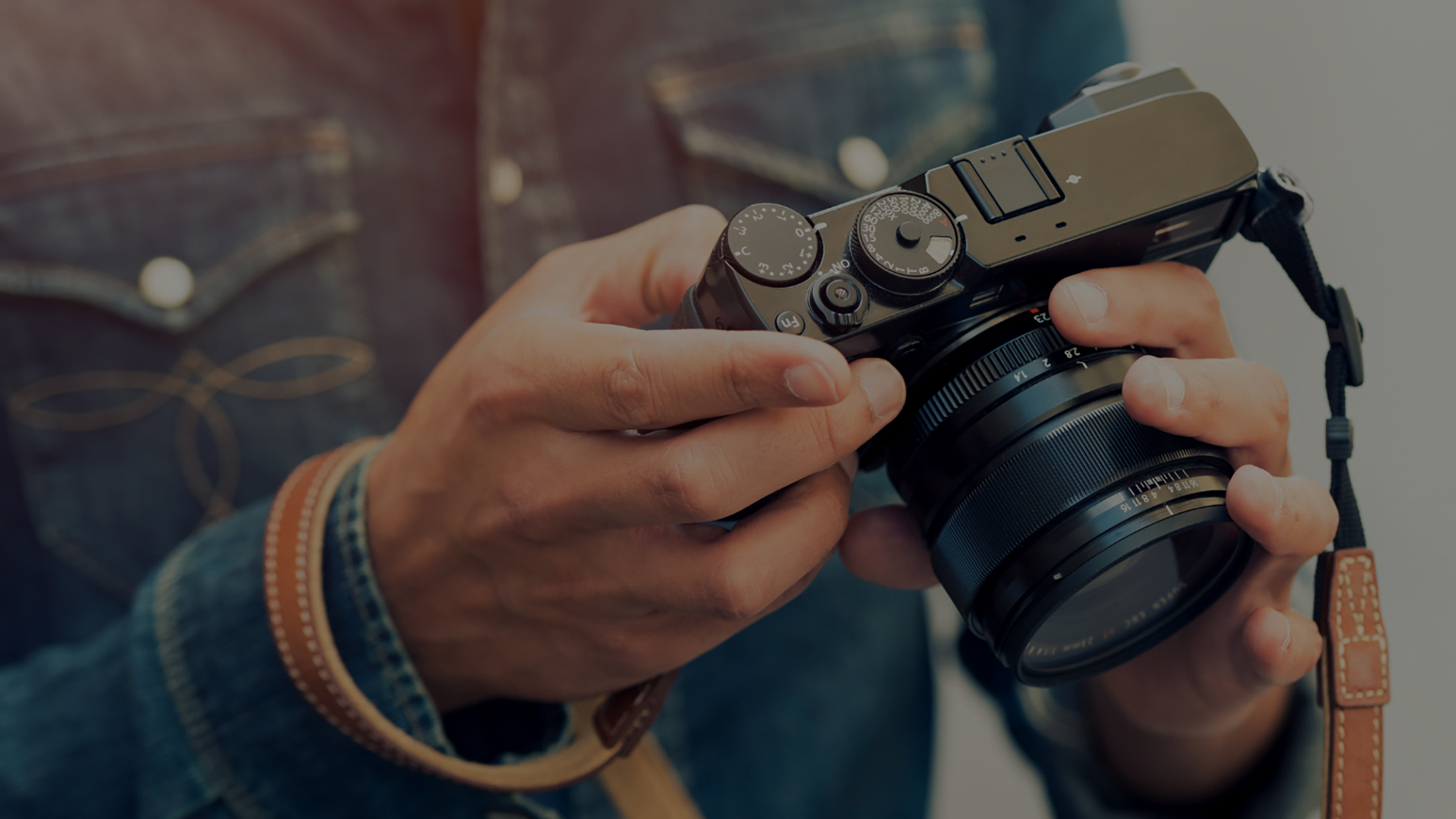Hands holding a camera, adjusting the lens