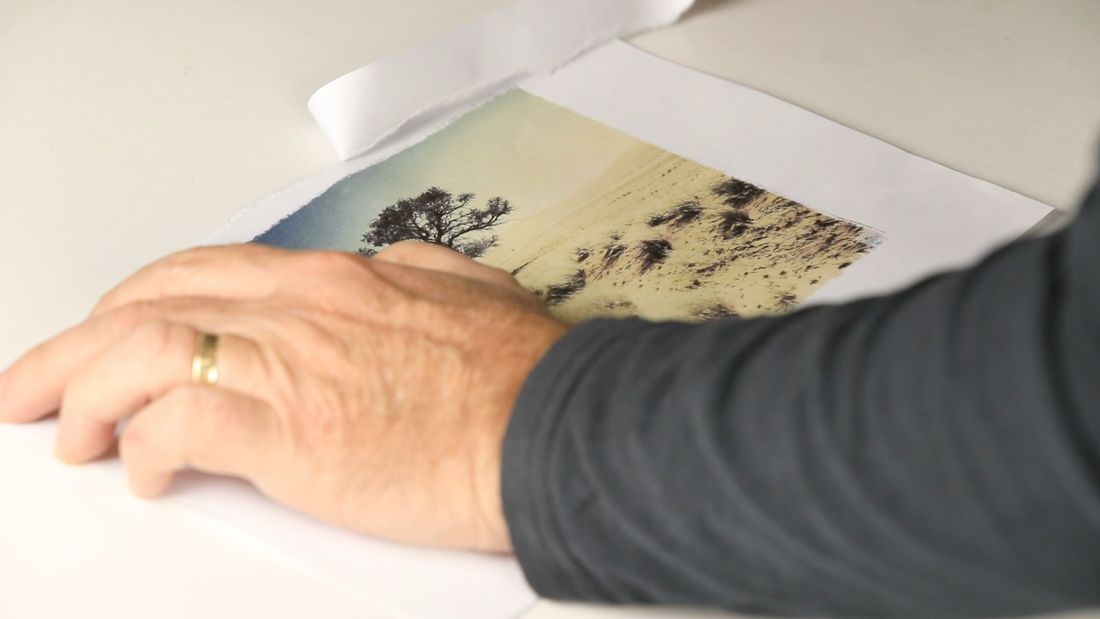 Hands working a luminance transfer flat on the bench