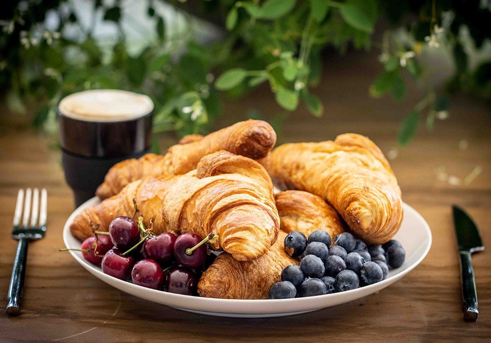 Croissants, berries and coffee laid out for breakfast
