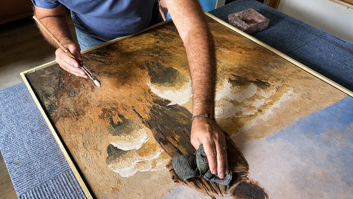 Martin Osner working into the surface of Eternal Shepherd with a brush and a cloth