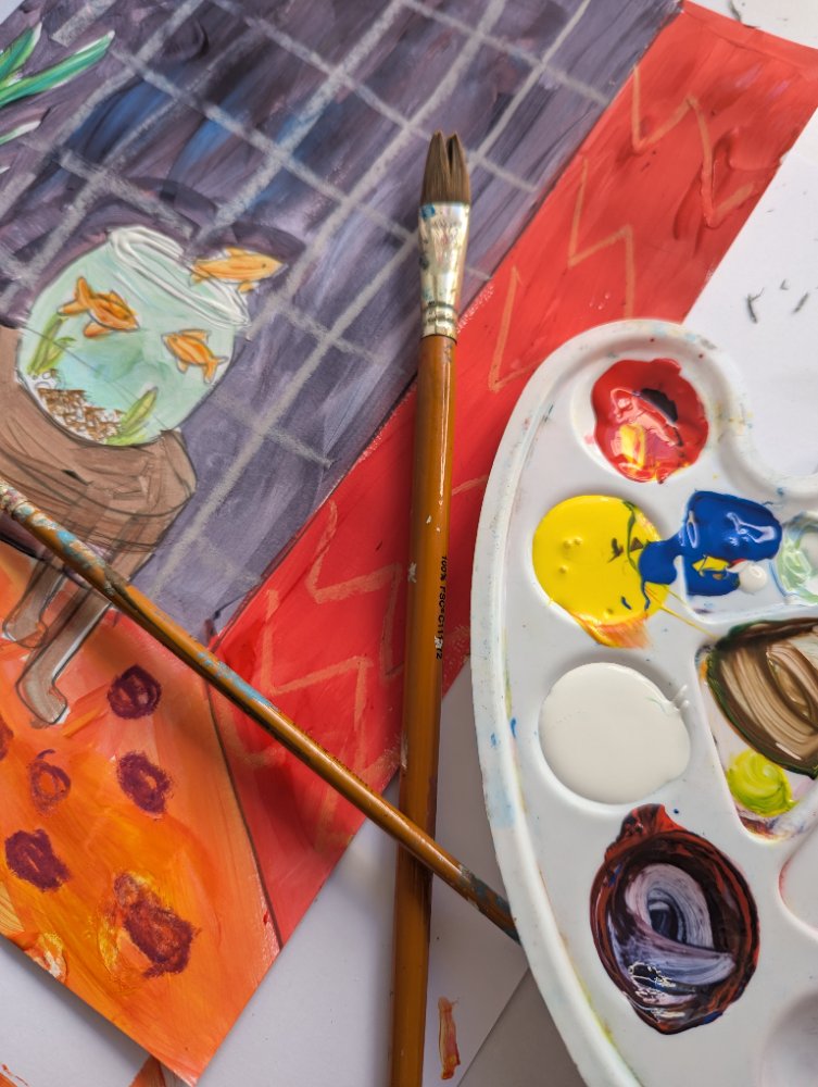 A goldfish-bowl painting beside a brush and palette