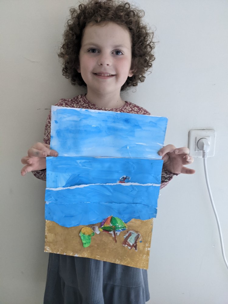 A curly-haired child proudly holding up a painted beach scene