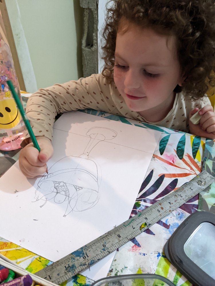 A focused young girl sketching a still life in pencil