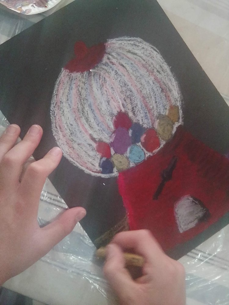 An oil-pastel gumball machine drawn on black paper
