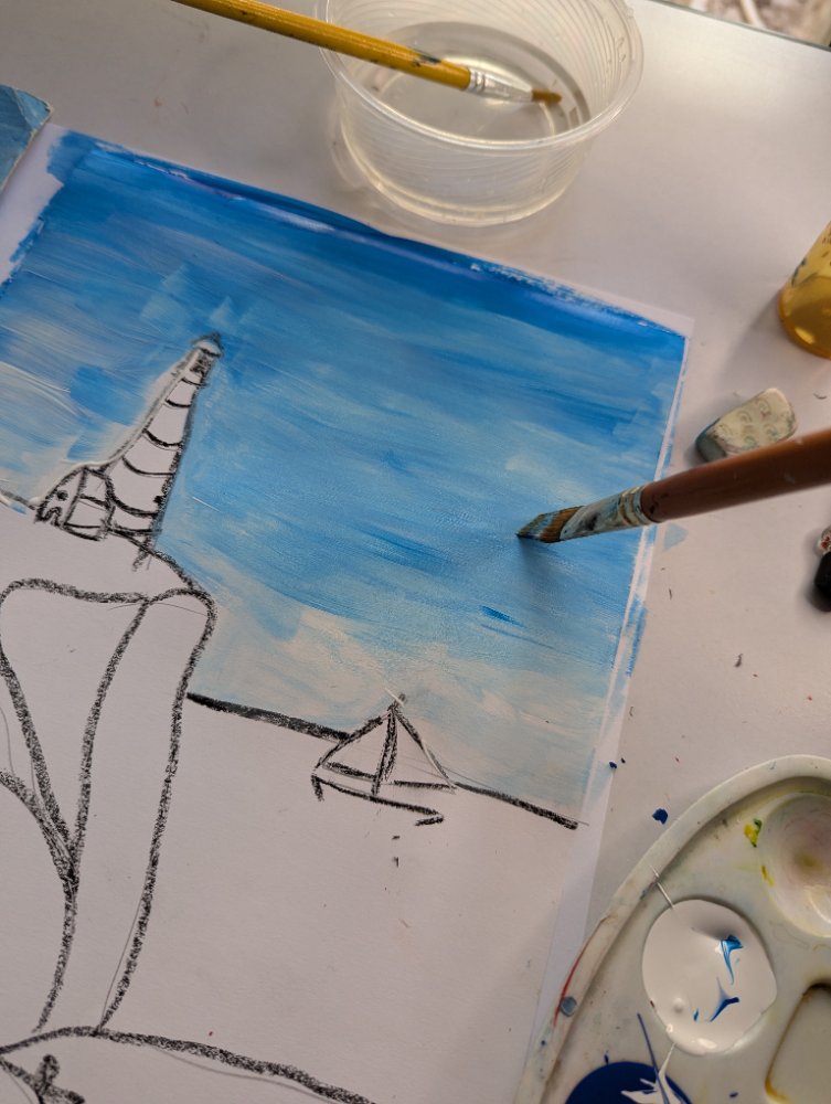 A beach-and-lighthouse painting being blocked in