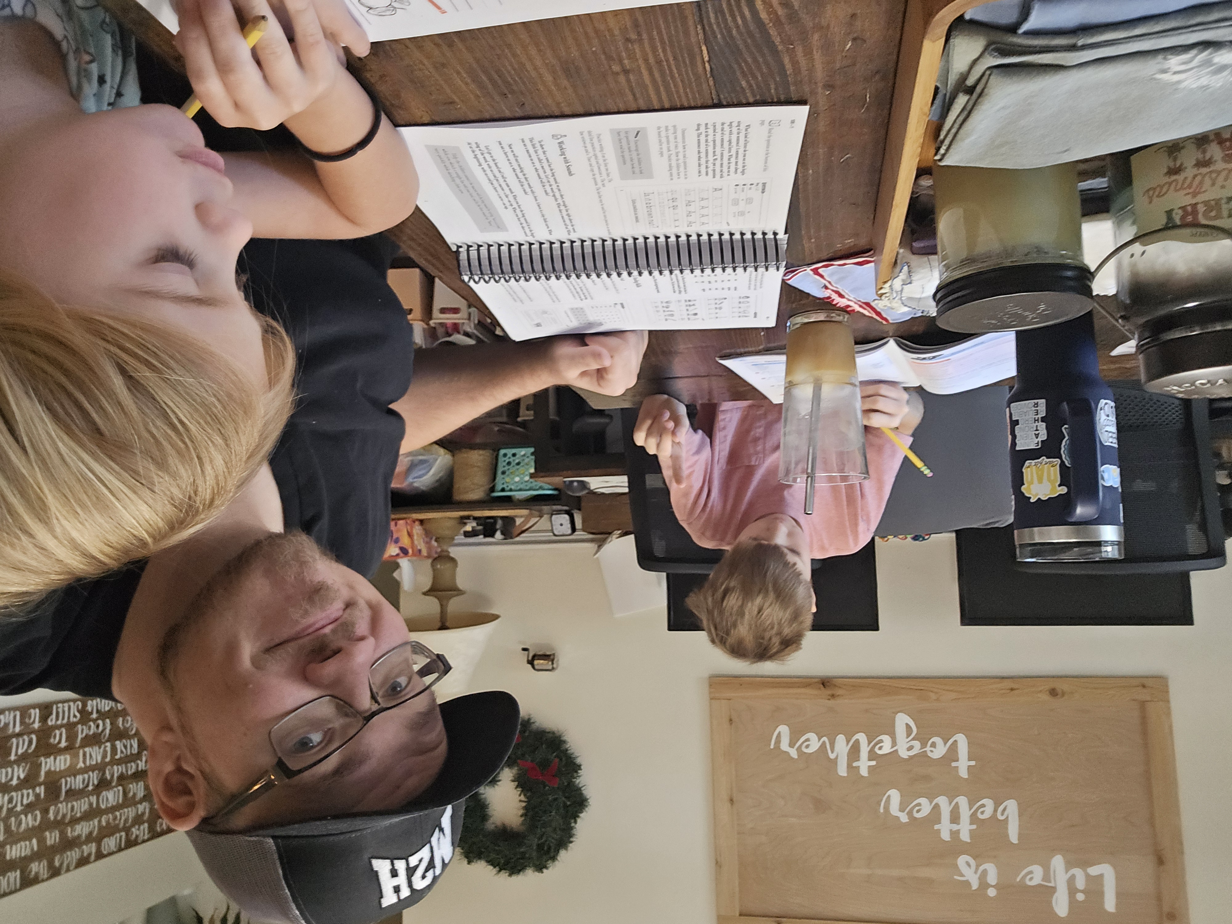 Brandon Beckley homeschooling with his kids at the kitchen table.