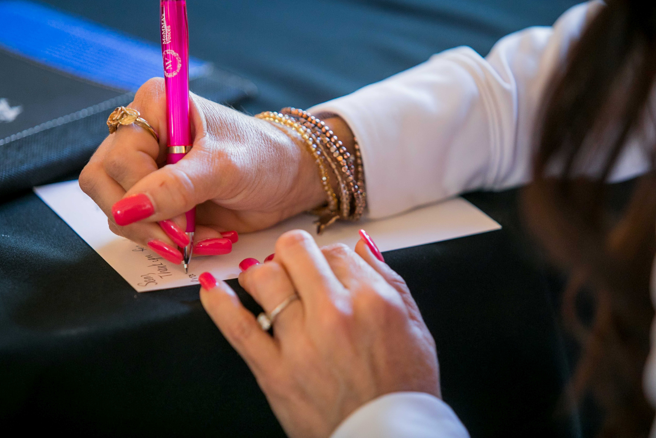 A patient writing a note with a MoMMAs Voices pen