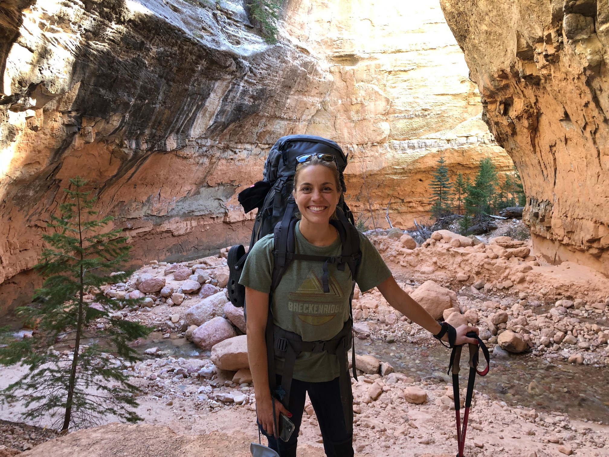 Jenna hiking with a full pack in a red rock canyon