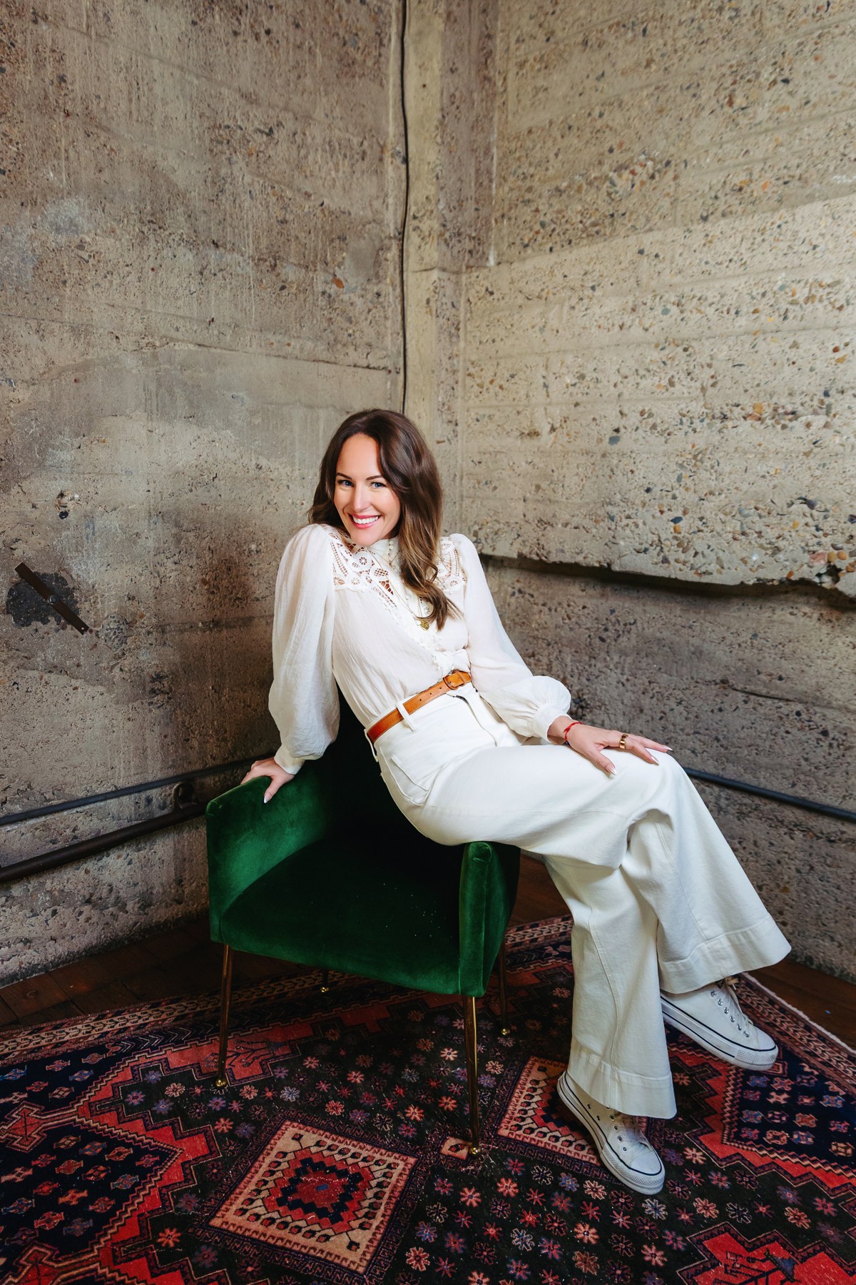 Amanda Benson. Full seated portrait with crossed legs.